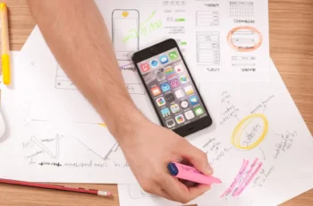 person at a desk using multi-coloured pens and sheets of paper to make a content strategy framework