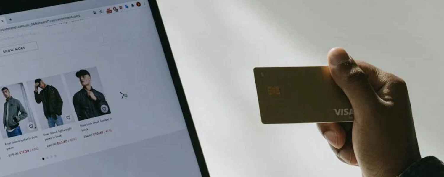 Person holding debit card while browsing ecommerce content with AI or human-written product descriptions